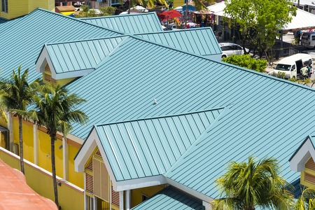 arial view of a green metal roof on a yellow apartment complex